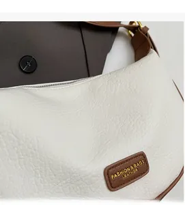 Detailed macro view of white lychee leather texture and brown leather logo patch