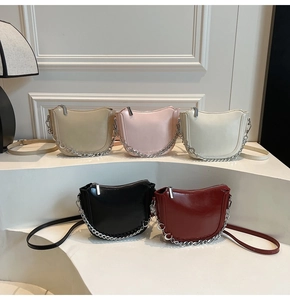Saddle bags in five colors with silver chain detail on minimalist white display stands