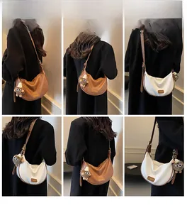 Detail view of lychee leather crescent crossbody bag with plush doll charm in 6-grid layout
