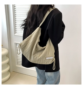 Detail of khaki pleated canvas tote with drawstring and Superior woven label