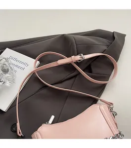 Detail of pink PU leather handbag with adjustable strap and silver metal chain accessory