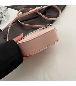 Detailed bottom view of the pink saddle bag showing durable stitching and silver chain