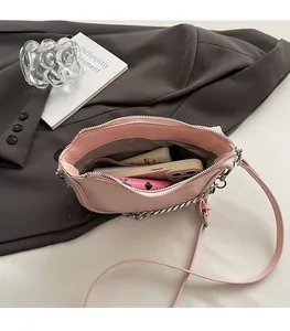 Pink leather saddle bag interior showing organized space for phone and makeup