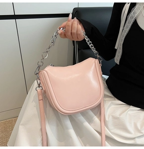 Detail of pink saddle bag with silver chain handle and moon pendant charm decoration