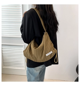Detail of dark khaki canvas hobo bag with pleated texture and Superior brand label