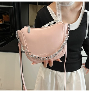 Detail of light pink moon bag featuring silver chunky chain and crescent moon pendants
