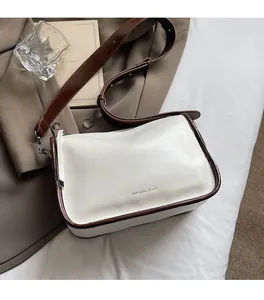 Détail du cuir PU crème avec bordure marron et bandoulière réglable souple