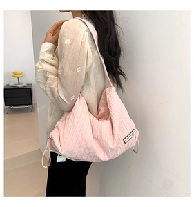 Detail of pink quilted hobo bag featuring adjustable drawstring and Superior label