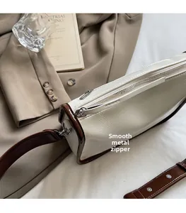 Détail du zip en métal argenté sur le sac polochon en cuir crème et marron vintage