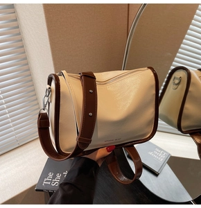Détail du sac bandoulière en cuir PU crème avec sangle brune et logo MAUDAI BEAR