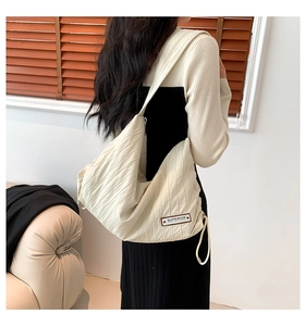 Detail of off-white pleated tote bag showing the vintage Superior label and fabric texture