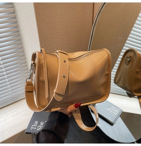 Détail du sac à main beige en cuir grainé avec bandoulière large et finitions en métal argenté