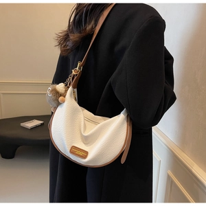 Detail of half-moon bag featuring litchi grain leather and fashion leather label