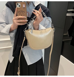 Chic beige hobo saddle bag with silver chain strap shown in a mirror selfie style