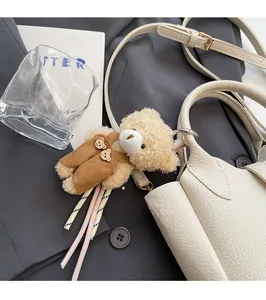 Ciondolo orsetto di peluche su borsa in pelle bianca con corda a righe e anello