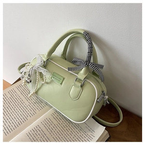 Close-up of Matcha green leather bowling bag with lace trim and pearl pendant details