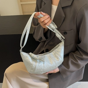 Detail of silver metallic crescent bag with unique pleated texture and knotted strap