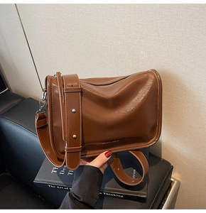 Détail du sac oreiller en cuir souple marron avec boucle en argent et logo de marque