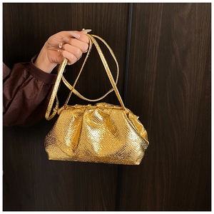 Close-up of metallic gold snakeskin crossbody bag with elegant pleated cloud design