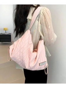 Large soft pink quilted canvas tote bag with Superior patch in a minimalist room