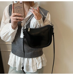 Close-up of black matte hobo bag featuring silver chunky chain and leather strap