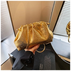 Detail of gold pleated dumpling bag with crocodile pattern and slim shoulder strap