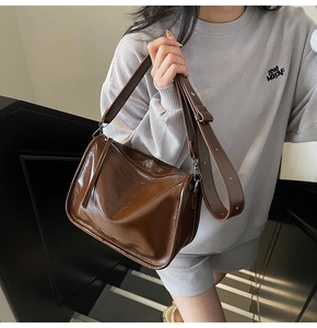 Sac bandoulière en cuir verni marron brillant avec détail de large sangle réglable