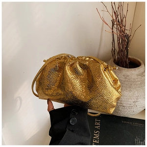Detail of gold metallic dumpling bag featuring pleated snake-texture synthetic leather