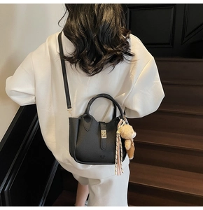Vista posteriore dettagliata di una borsa nera in pelle testurizzata su una scala di marmo