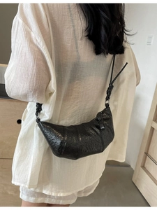 Minimalist black croissant shoulder bag with pleated texture and knotted strap