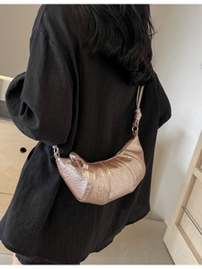 Metallic rose gold croissant shoulder bag with pleated texture and adjustable strap for women