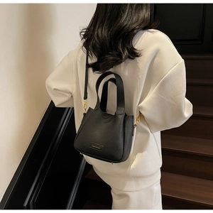 Detailed close-up of a black lychee texture bucket bag with elegant gold hardware