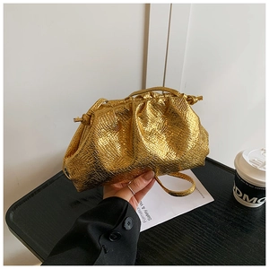 Close-up of golden cloud bag featuring snake pattern texture and drawstring closure
