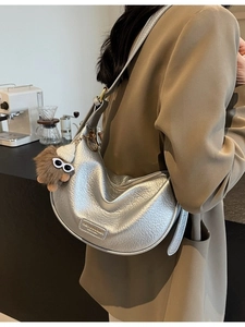 Silver crescent hobo bag with pebble leather texture and fuzzy monster charm for women
