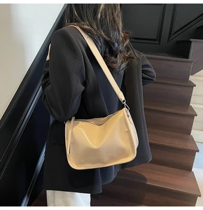 Sac à main beige en cuir grainé avec large bandoulière, détail élégant de mode féminine