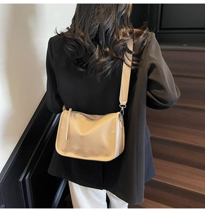 Détail du sac bandoulière en cuir crème grainé avec une large bandoulière confort