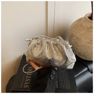 Macro detail of silver pleated cloud bag featuring metallic faux snake skin texture
