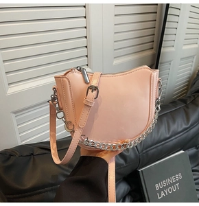 Detail of pink half-moon saddle bag featuring silver chain and moon-shaped charm