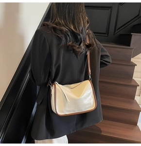 Gros plan d'un sac bandoulière beige et marron chic présenté dans un décor de studio