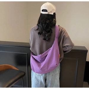 Rear view of a casual purple canvas crescent bag showing natural drape and large capacity