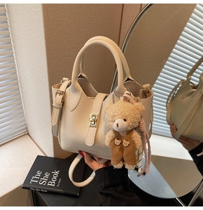 Dettagli della borsa tote color crema in pelle martellata con chiusura dorata e orsetto
