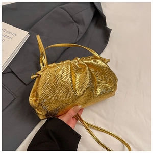 Close-up of golden snakeskin embossed cloud bag featuring elegant pleated texture and strap