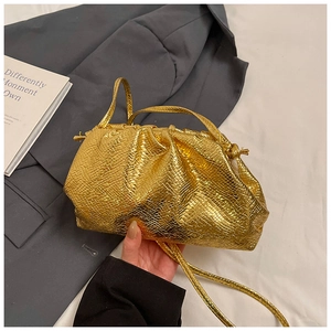 Detail of gold metallic cloud pouch with snake skin texture and drawstring closure