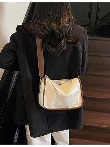 Sac bandoulière tendance blanc crème avec large sangle porté par un mannequin