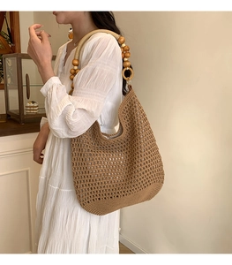 Détail du sac cabas au crochet avec bandoulière en perles de bois clair élégantes