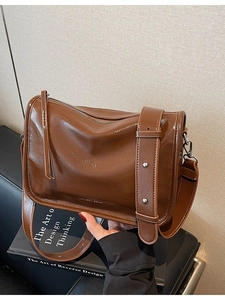 Sac bandoulière vintage marron en cuir verni brillant avec large sangle et logo MAUDAI