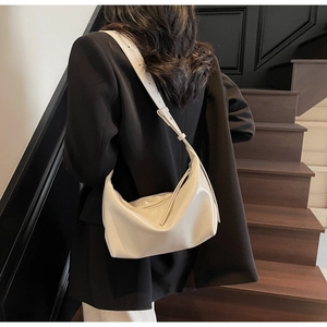 Minimalist cream white hobo bag shown from the back in a stylish lifestyle setting