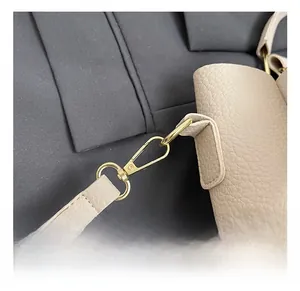 Detailed macro view of litchi texture leather and gold spring hook on the bucket bag