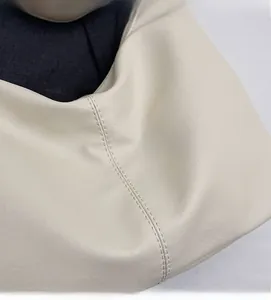 Close-up of cream faux leather material and high-quality stitching on a tote bag