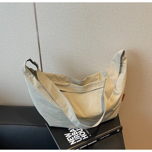 Close-up of lightweight nylon crescent bag on props highlighting the side orange label